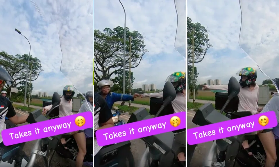 Netizens were charmed by a female pillion rider who began handing out sweets at a traffic light. 