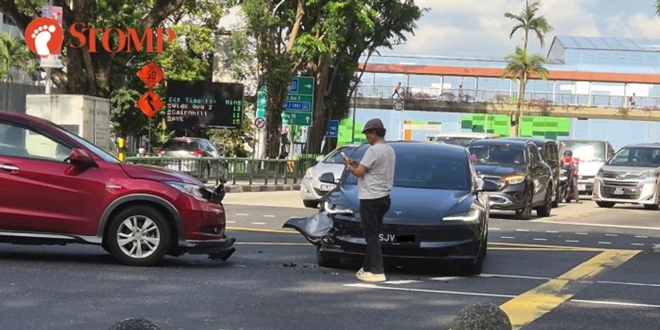 A red Honda Vezel and a black Tesla with their front bumpers damaged.