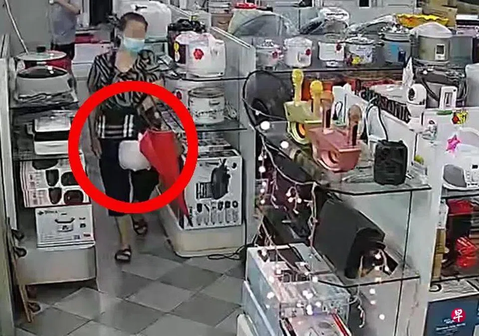 The woman used an umbrella and her handbag to conceal the rice cooker. 