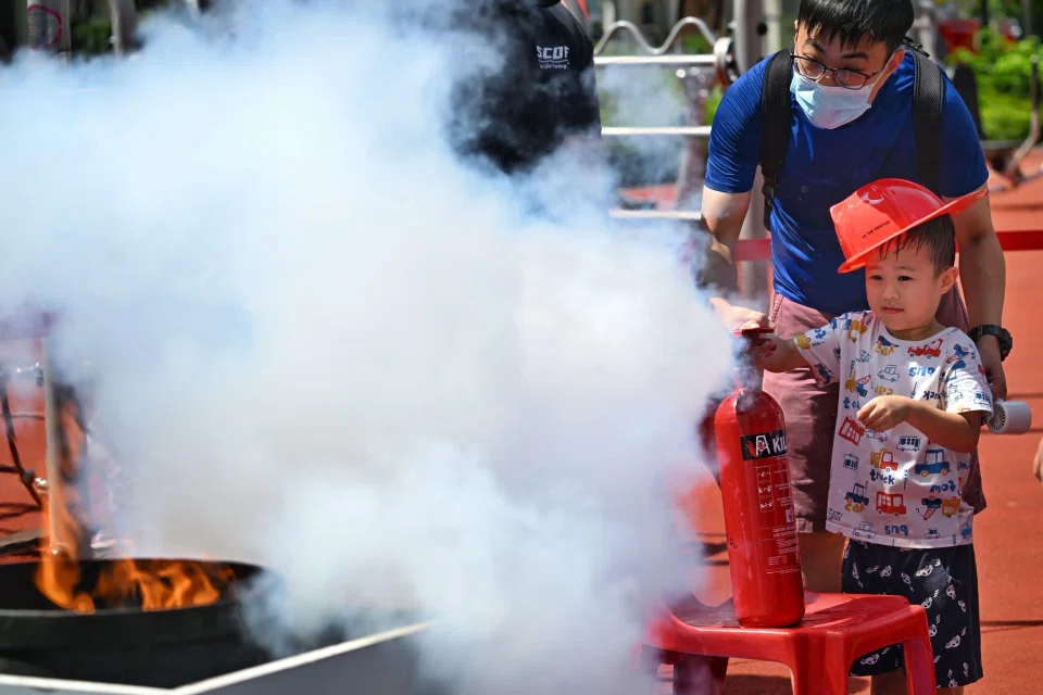 Residents trying to put out a fire at Chua Chu Kang GRC and Bukit Gombak SMC’s Community Resilience Day event on May 25.