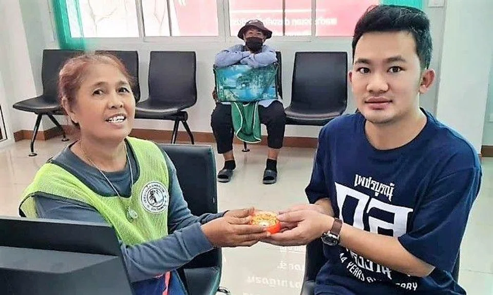 Ms Ratree Chumwong returning the gold to Mr Ittiphon.