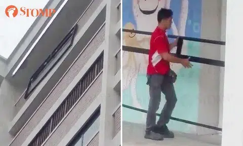 Workers use rope to lift window grille from ground floor to highest storey of Bukit Batok block