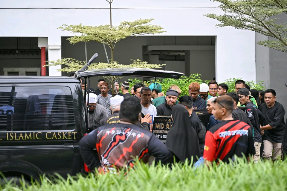 The body of the man who died from the blaze being transferred into a van to be transported to the Muslim cemetery for burial.
