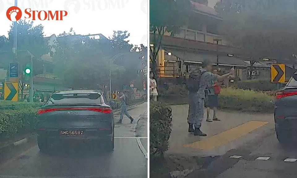 man in uniform points middle finger at driver after crossing on red man