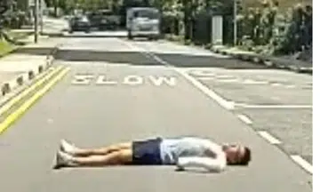 man lies on road in Tanglin