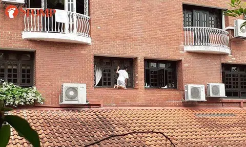 Woman kneels on narrow ledge to clean windows at Kheam Hock Road condo