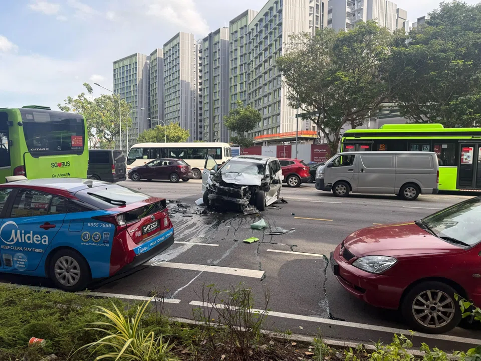 A black car with a damaged bumper and hood was seen on the third lane, with oil and debris surrounding it.