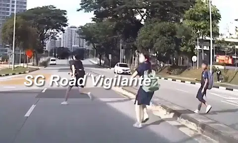 Schoolchildren dash across road at Sumang Walk to catch bus -- and almost get hit by car
