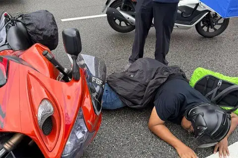 Mr Djohan Abdul Rahman lying on the road after he was caught between a car and a bus in a traffic accident.