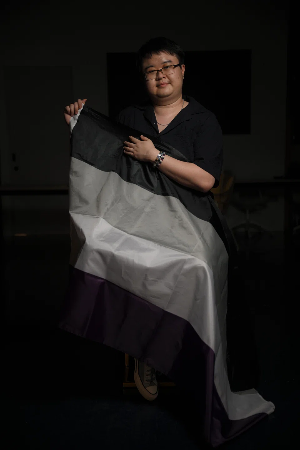 Lyndon Ang, holding the asexual flag, says the community has played an important role in helping them come out of their shell.