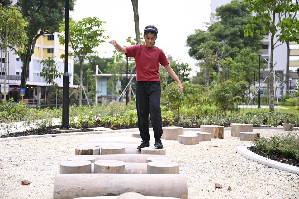 The nature-inspired play area in Pek Kio Park features logs and stumps to spark imagination and encourage adventurous play among children.