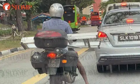 Doesn't this motorcyclist have a safer way of transporting metal ladder?