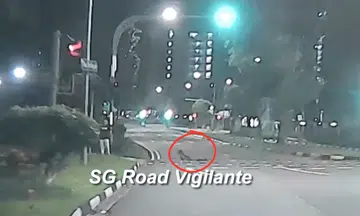 boy cross road in CCK while lying on skateboard