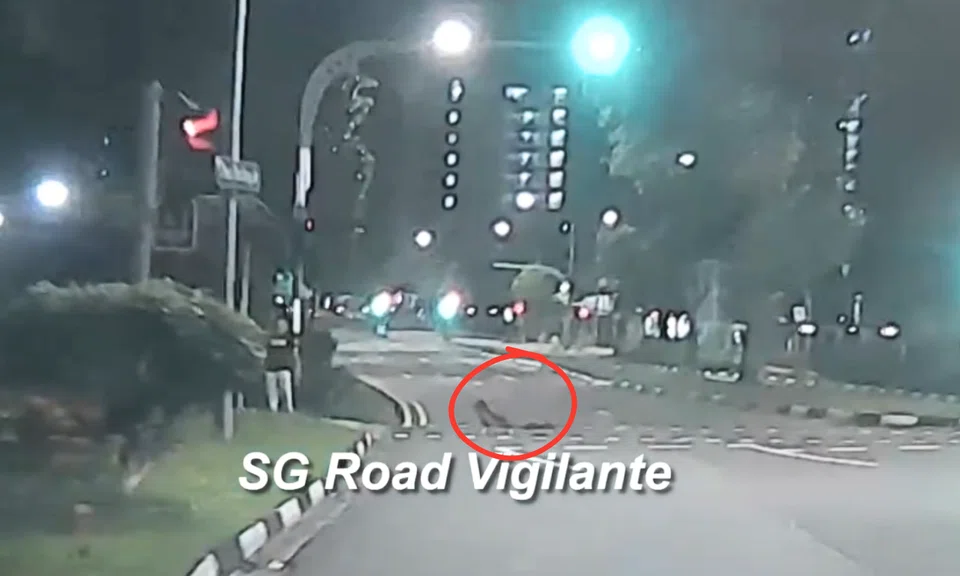 boy cross road in CCK while lying on skateboard