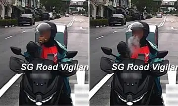 motorcyclist in lalamove uniform vapes on road