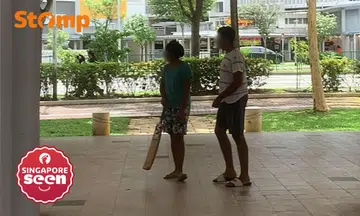 Youths playing cricket at Sengkang void deck