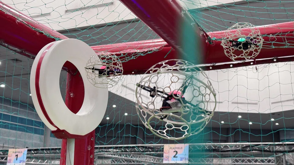In drone soccer, strikers score goals by flying their drones through hoops, while defenders block them.