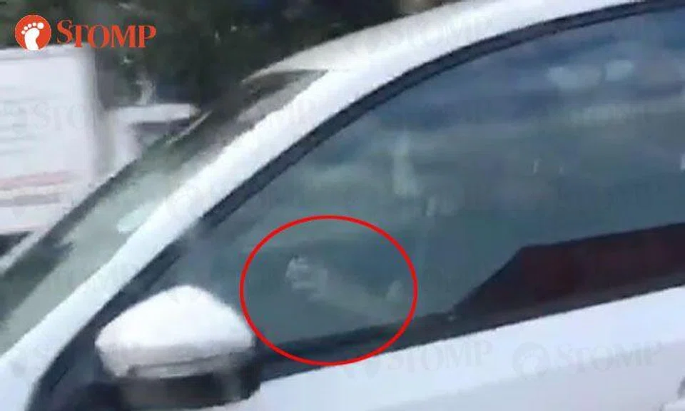 Clearly not a genius: Guy attempts to solve Rubik's Cube while driving in Bedok