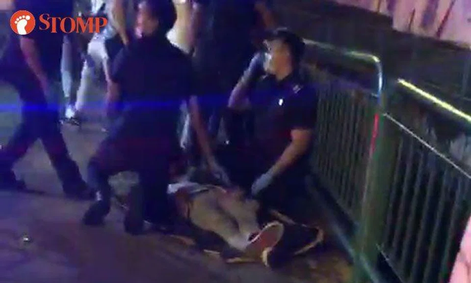 SCDF personnel carry person on stretcher outside SAFRA Yishun