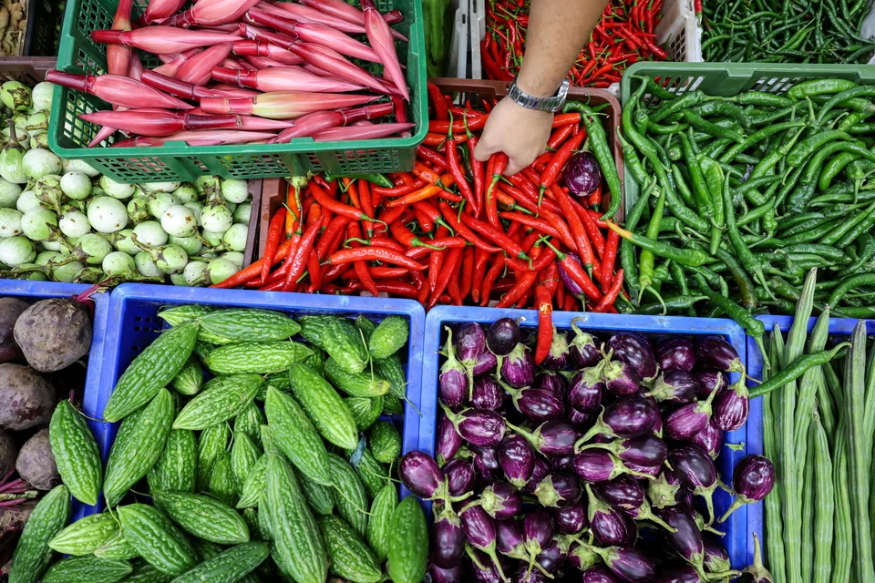Mr Azfar Maswan buying chillies from Chia's Vegetable Supply at Tekka wet market.