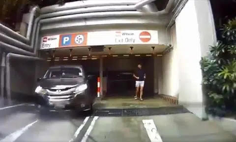 Driver gets passenger to look out for traffic and then exits via carpark entrance