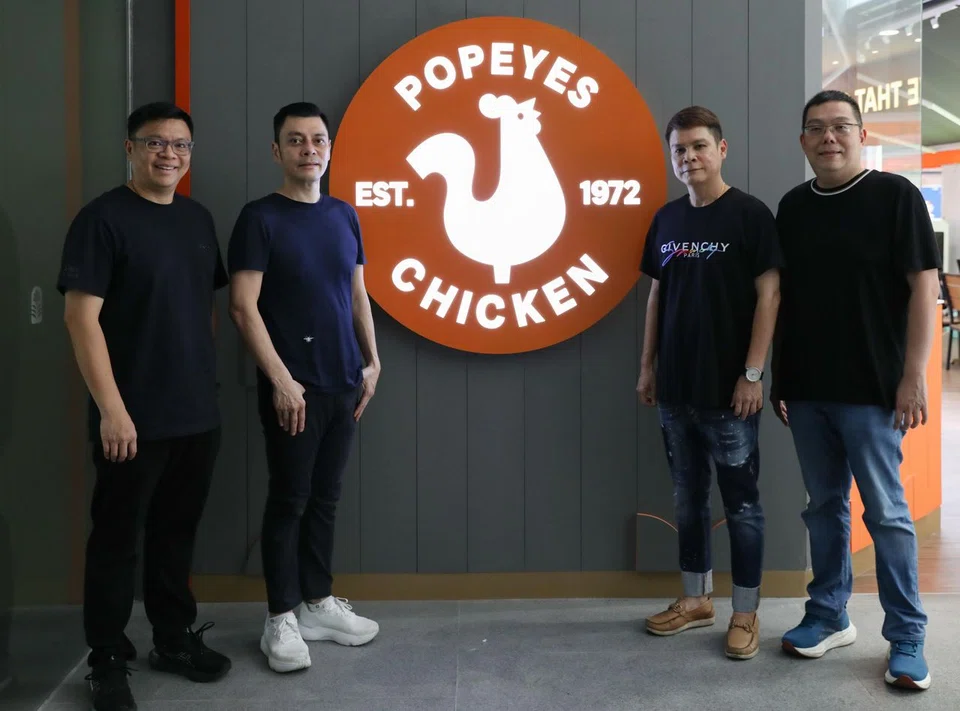 (From left) Fei Siong Group's executive director Tan Kim Leng, founder and chairman Tan Kim Siong and directors Tan Kim Beng and New Mun Kit at their Popeyes outlet.