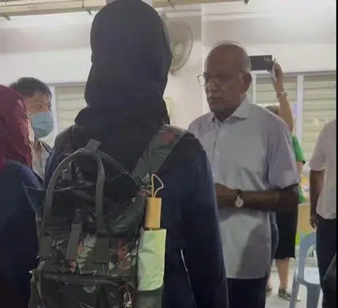 Mr Shanmugam speaking to the two women after the pair shouted "coward" at him.