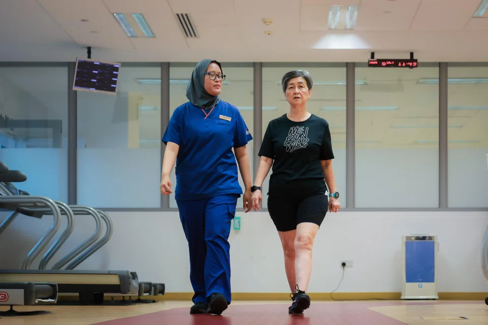 Senior physiotherapist Nadiah Mohamed Rahim gets Madam Teo to warm up with a walk before exercise.