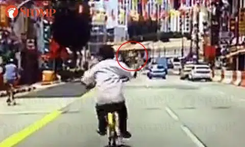 Cyclist points middle finger at driver, kicks her car and 'runs away' after getting honked at