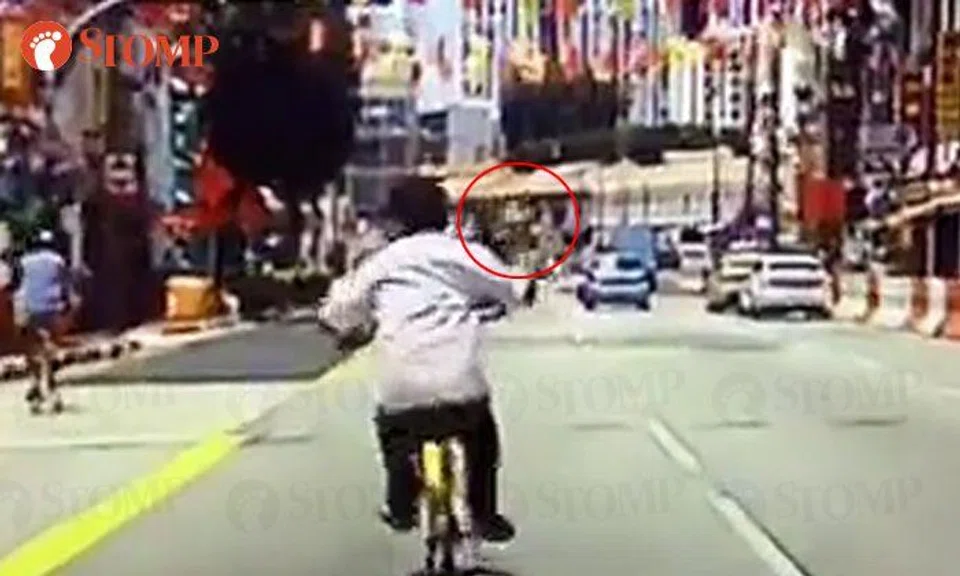 Cyclist points middle finger at driver, kicks her car and 'runs away' after getting honked at