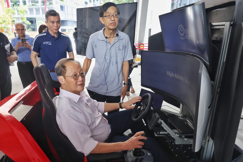 Manpower Minister and Second Minister for Trade and Industry Tan See Leng Tan See Leng viewing a tele-forklift control station, accompanied by Commonwealth Kokubu Logistics managing director Daniel Tan (left) and National Robotics Programme chief executive Quek Tong Boon at RoboSG! 2025.