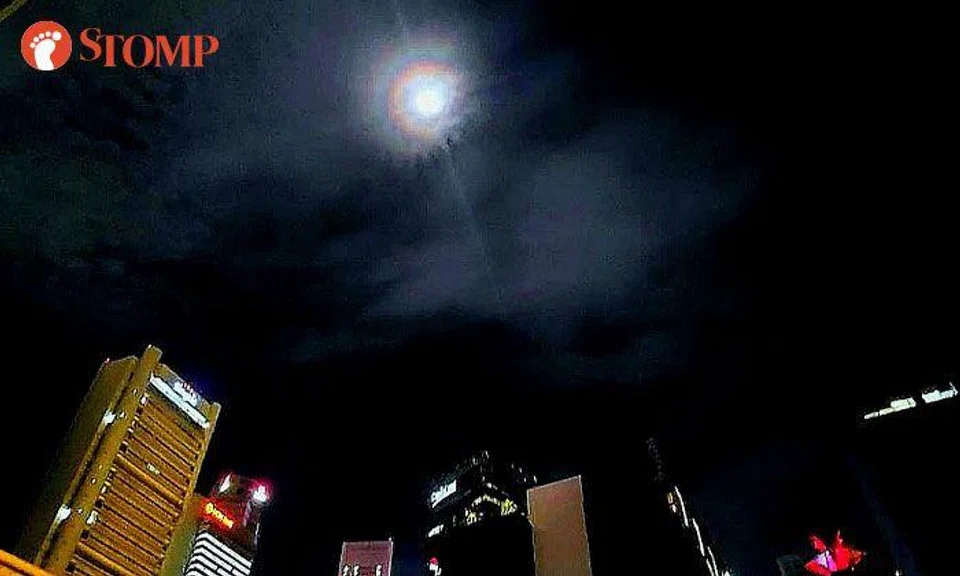 Man in awe of moon with beautiful rainbow halo that shone down on Singapore