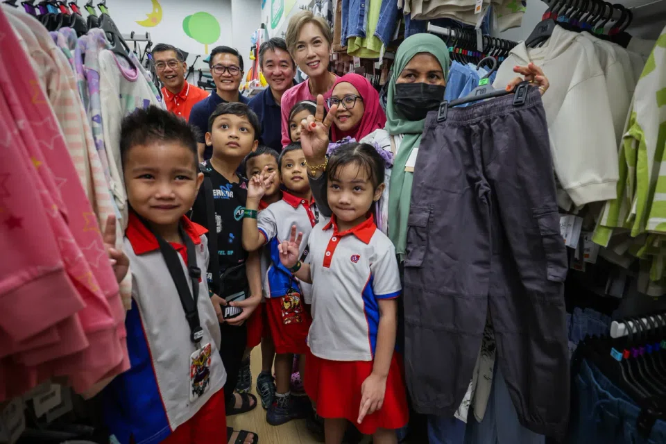 PCF chief executive Victor Bay (top left) and Minister for Digital Development and Information Josephine Teo (centre, in pink top) in a group photo with beneficiaries at the launch of KidStart Sparkle Homes at the Mothercare Experience Store at HarbourFront Centre on Oct 18.