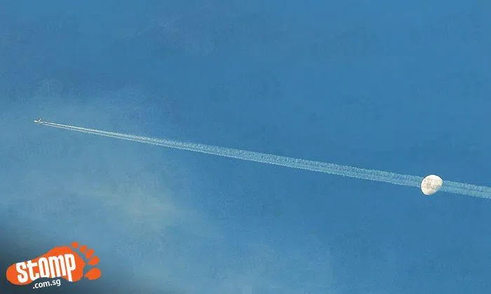 Beautiful shots of aircraft contrails cutting through Waxing Gibbous ...