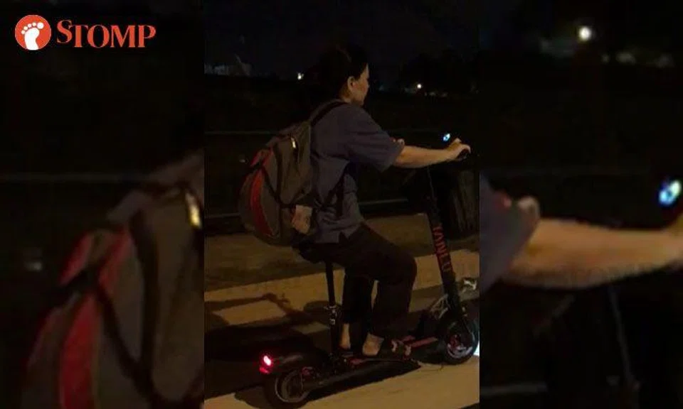Woman rides e-scooter on road near Causeway Point