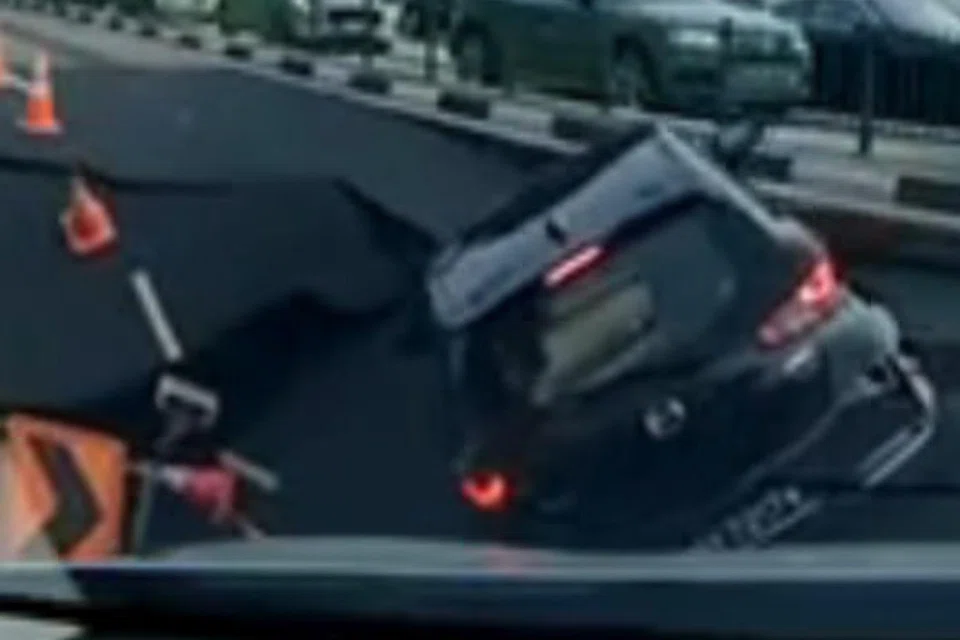 Foreign workers intervened after a car fell into a sinkhole along Tanong Katong Road.