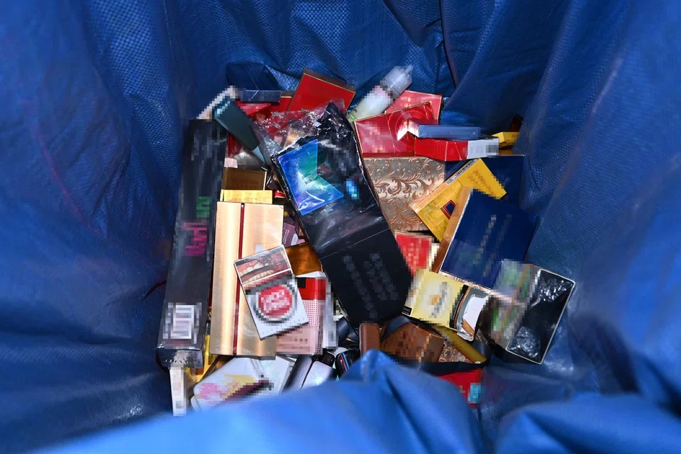 Confiscated boxes of cigarettes and vapes in a bin at the arrival hall of Changi Airport Terminal 1.
