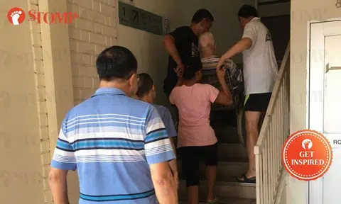 Sin Ming Rd shopkeeper rallies group to help elderly wheelchair-bound man up flight of stairs