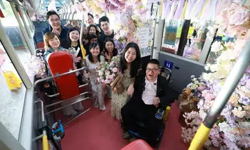 Alister Ong and Jasmine Kurniawan celebrating his marriage proposal on board Tower Transit’s wedding bus.