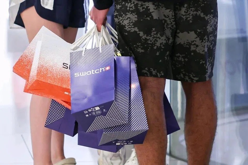 A shopper carrying seven Swatch shopping bags after the launch of the Royal Pop watch collection.