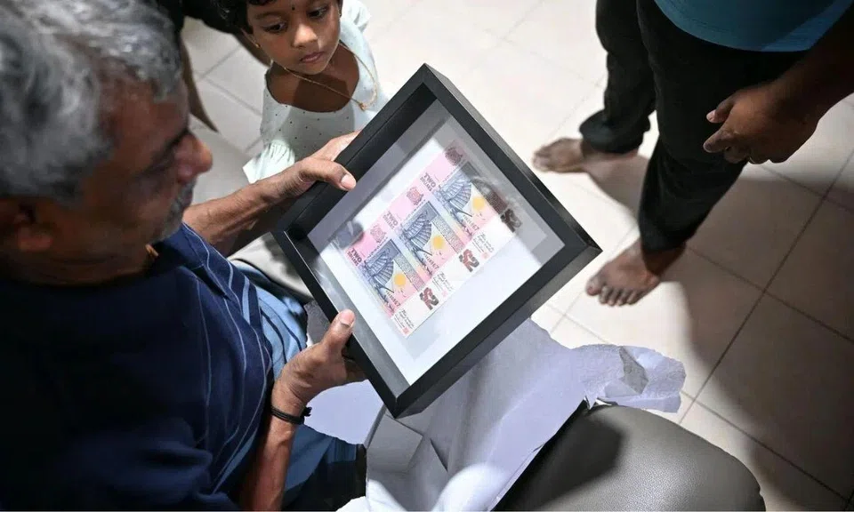 Man holding a frame of $2 notes