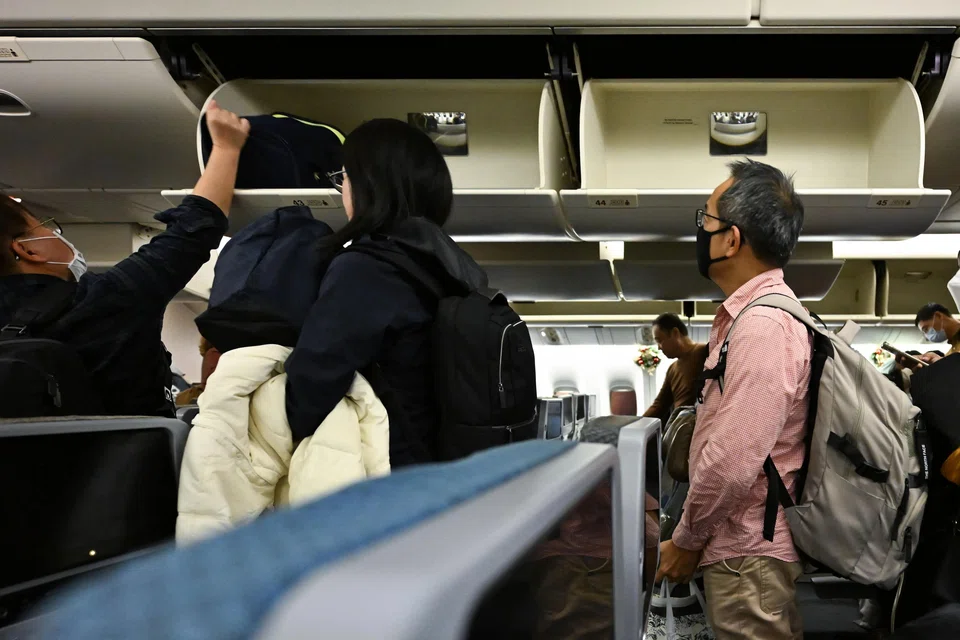 A 35-year-old man was seen taking items from a bag in the overhead compartment that did not belong to him.