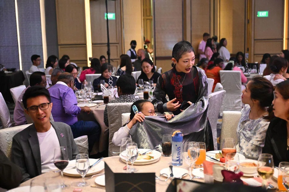 Attending the Courage Catwalk 2025 fashion show are Ms Lim’s husband Chong Ser Jing (left) and niece Mavis Tan, who is intrigued by her costume.