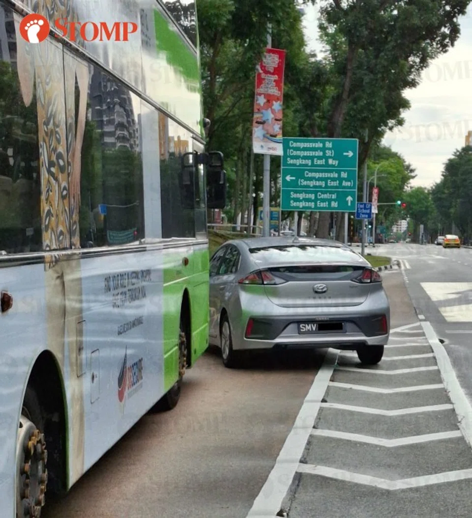 The car driver moved his car to prevent the bus from leaving