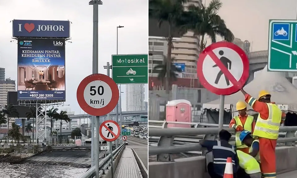 Workers putting up the signboards along the Johor-Singapore Causeway.