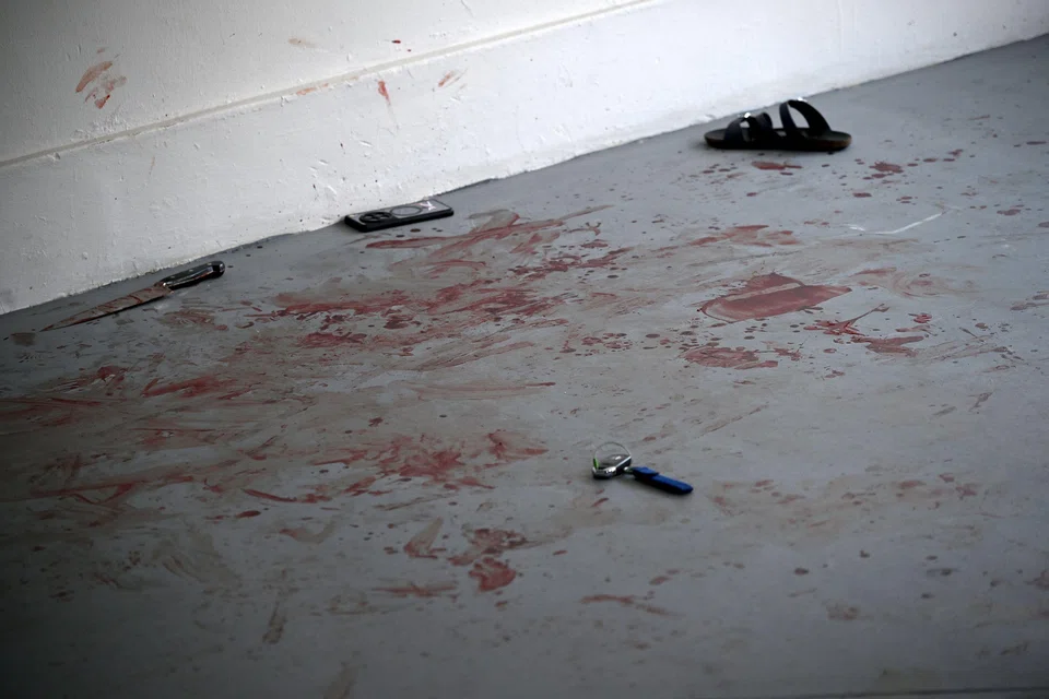 A knife, a watch, a mobile phone, a set of car keys and a slipper lay on the bloodied floor. ST PHOTO: KUA CHEE SIONG