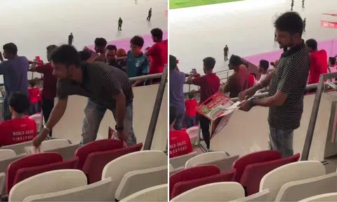 man picks up flyers from the ground after sg bangladesh football match