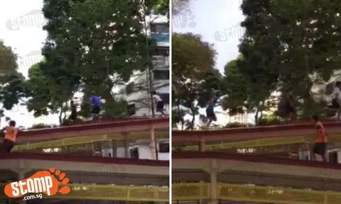 Group of young boys climb on top of roof of sheltered walkway at Bukit Merah HDB estate