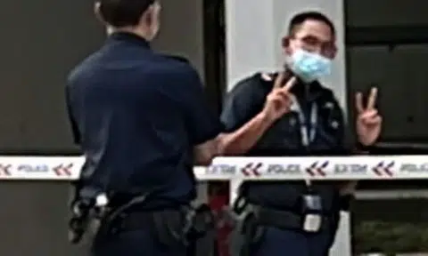 Police apologise after officer poses next to blue death tent