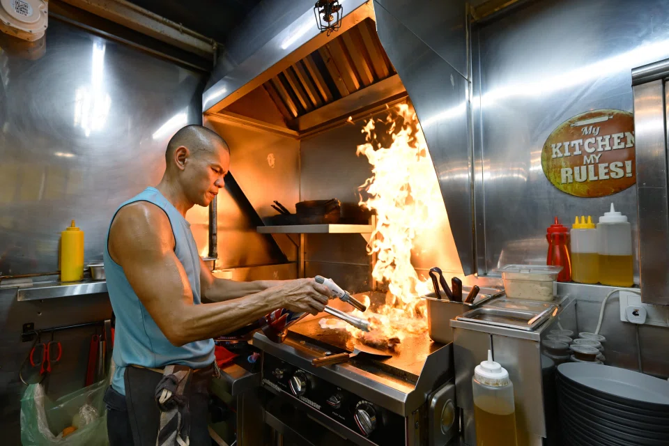 Mr Wan whips up Western fusion dishes in his stall. ST PHOTO: NG SOR LUAN